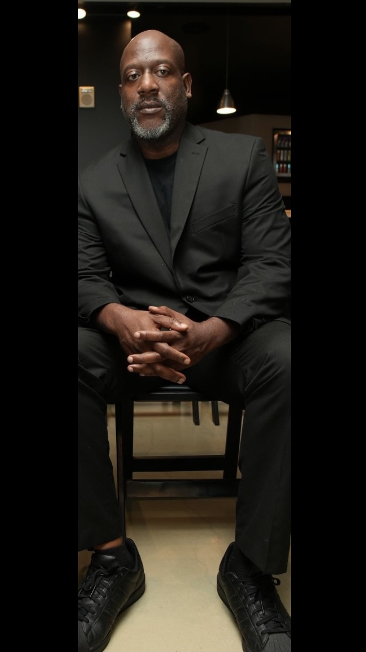 Tomike Ogugua seated in a black suit
